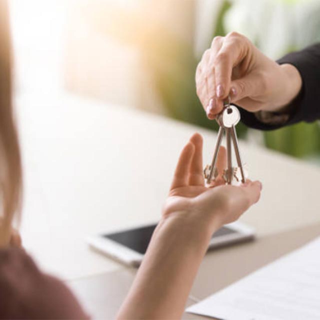 Man handing keys to woman