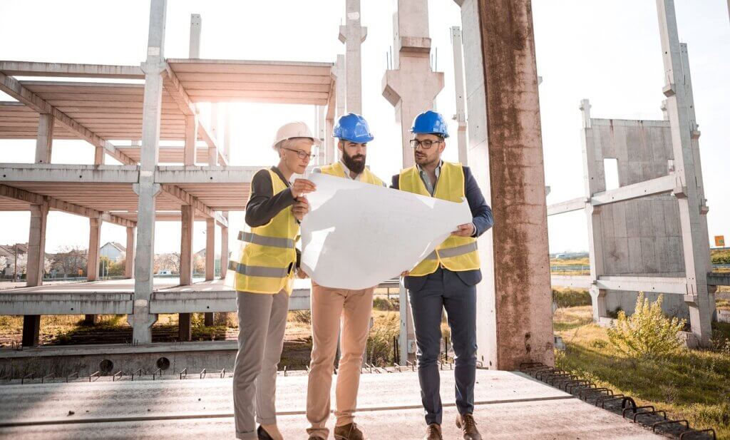 women and two men looking at building plans